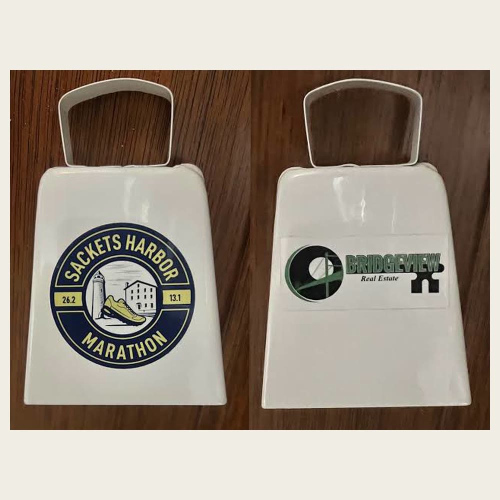 White souvenir cowbell, front with the race logo and back with the Bridgeview Real Estate sponsor